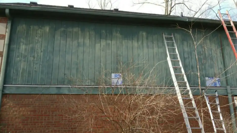 Rotten green wood siding and gutterboard on an Indianapolis home before Guy Painting repair