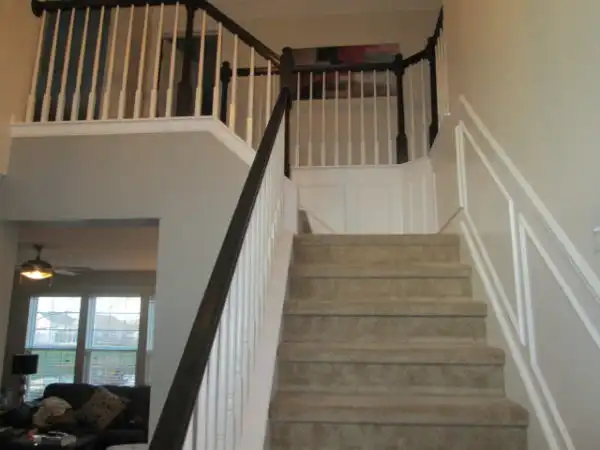 Stairway with black painted handrail and white spindles after painting