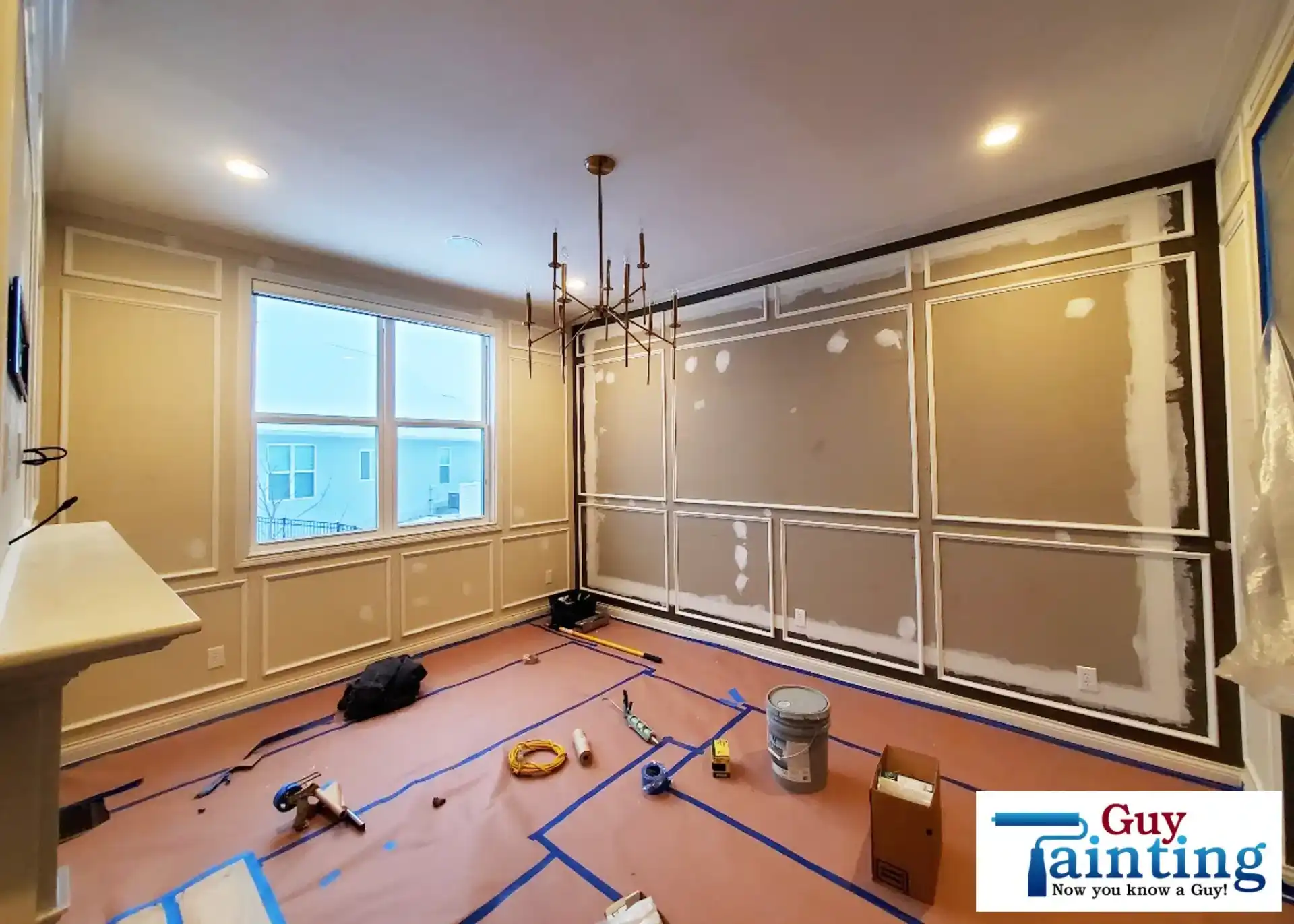 Carpenter installing raw wood picture frame moulding on a dining room wall