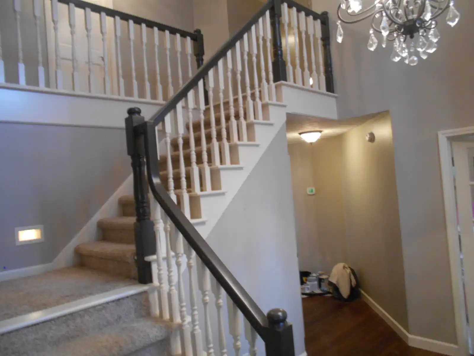 Curved staircase after Guy Painting refinished the balusters white with a dark espresso handrail and newel posts