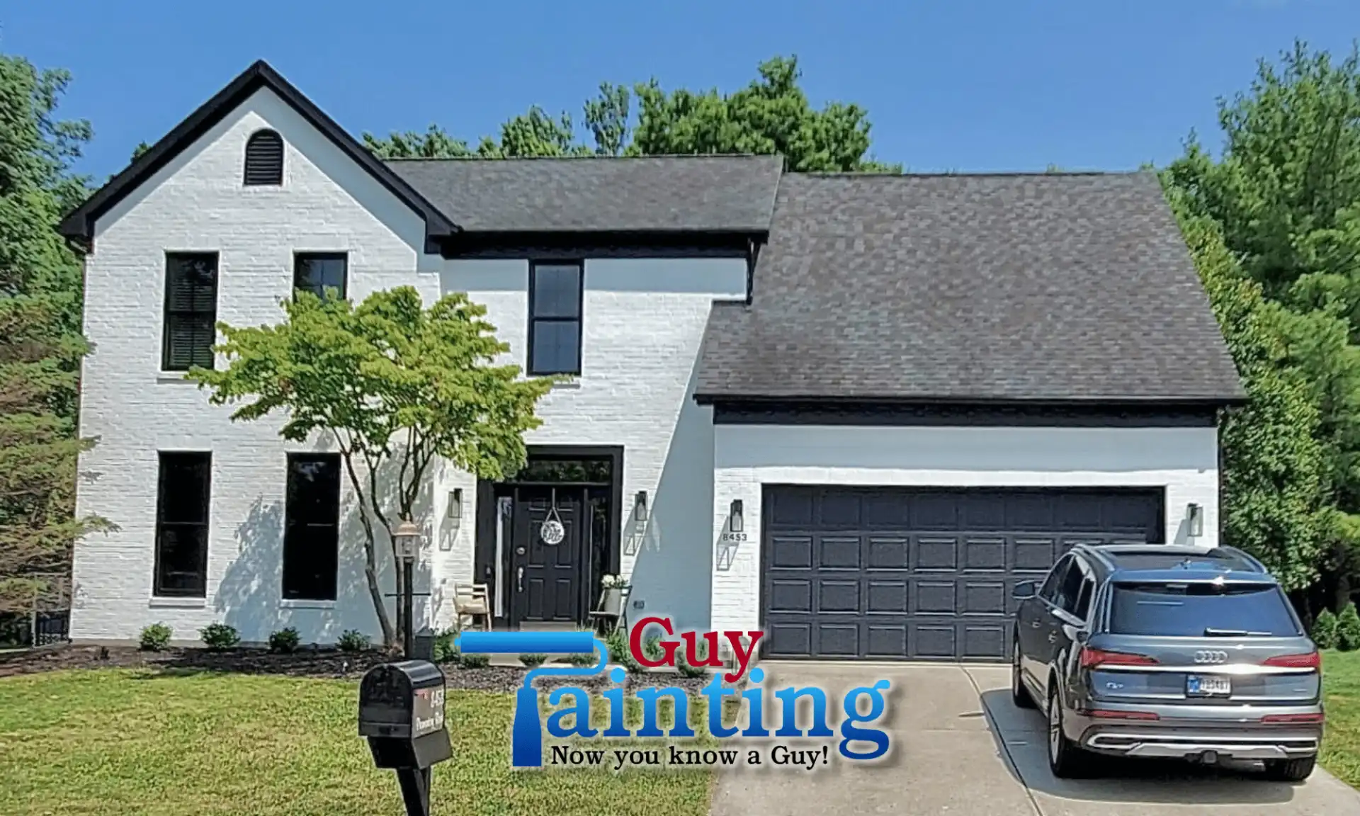 Same Geist home after Guy Painting's white brick exterior with black trim and black garage door
