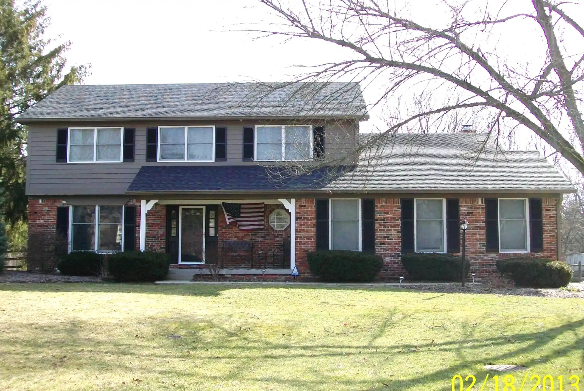 Central Indiana two-story home exterior with dark brown siding and shutters, before repaint